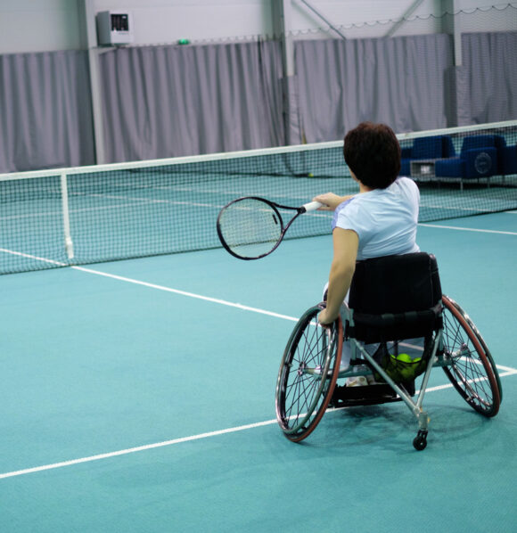 Portrait d'une femme en chaise roulante jouant au tennis
