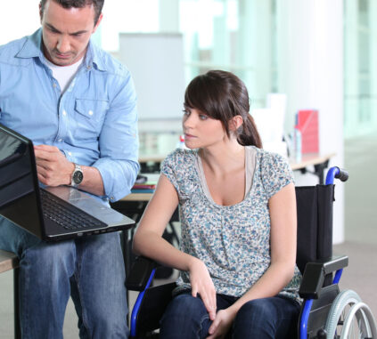 Portrait d'un homme avec un ordinateur portable et femme en chaise roulante
